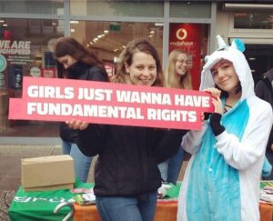 zwei Mädchen mit Einhornkostüm und einem Schild mit der Aufschrift "Girls just wanna have fundamental rights"